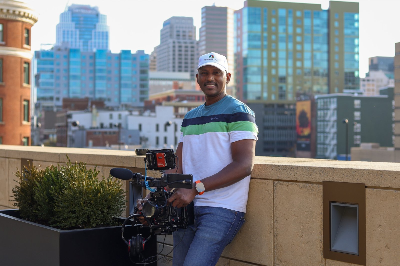 Souley Oumarou, founder of AmeriFilms, on a rooftop with the city skyline behind him